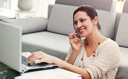 Woman talking on phone while on computer