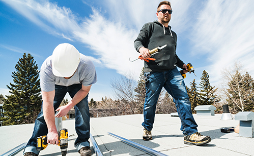 Two contractors installing solar panels